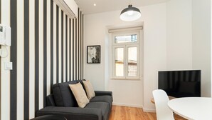Una sala de estar moderna con un sofá, una mesa de comedor y un televisor.