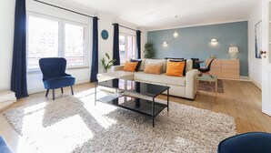 Un salon moderne avec un canapé, un fauteuil et une table basse.