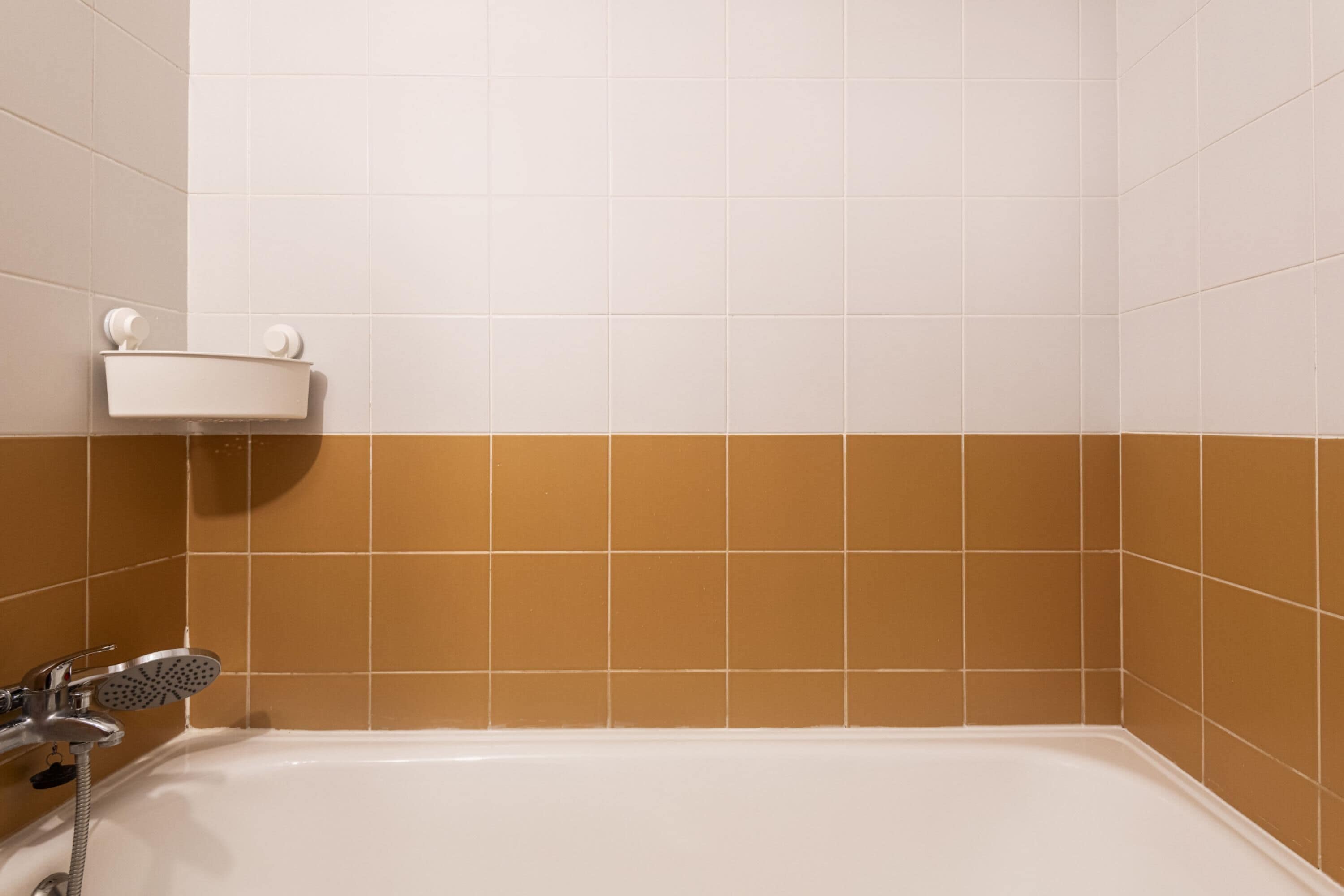 A bathroom with a bathtub, a shower, and a white shelf with a towel holder.