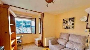 A living room with a sofa, a coffee table, and a view of the outside. - Kai Etxea , el mismo puerto de Bermeo (Bermeo)