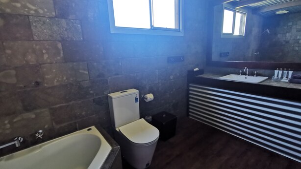 A bathroom with a bathtub, toilet, sink, and a window. - ORBOST MOTEL (Orbost)
