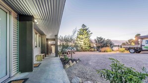 A modern building with a covered porch, a gravel driveway, and a parked truck. - ORBOST MOTEL (Orbost)