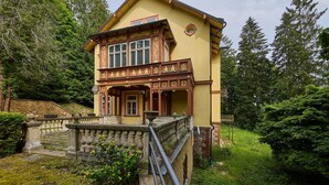 A two-story building with a balcony and a stone staircase leading up to it.