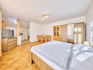 Une chambre moderne avec un grand lit, des meubles en bois, un bureau et une armoire.