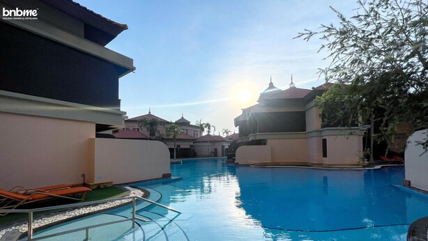 A swimming pool with a clear view of the sky and surrounding buildings. - 1B-AnantaraSouth-G02 by bnbmehomes (Dubai)