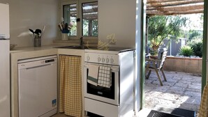 A compact kitchen with a dishwasher, oven, and a window above the sink. - TD Trulli Dell Uliveto Cozy Trulli With Pool (Castellana Grotte)