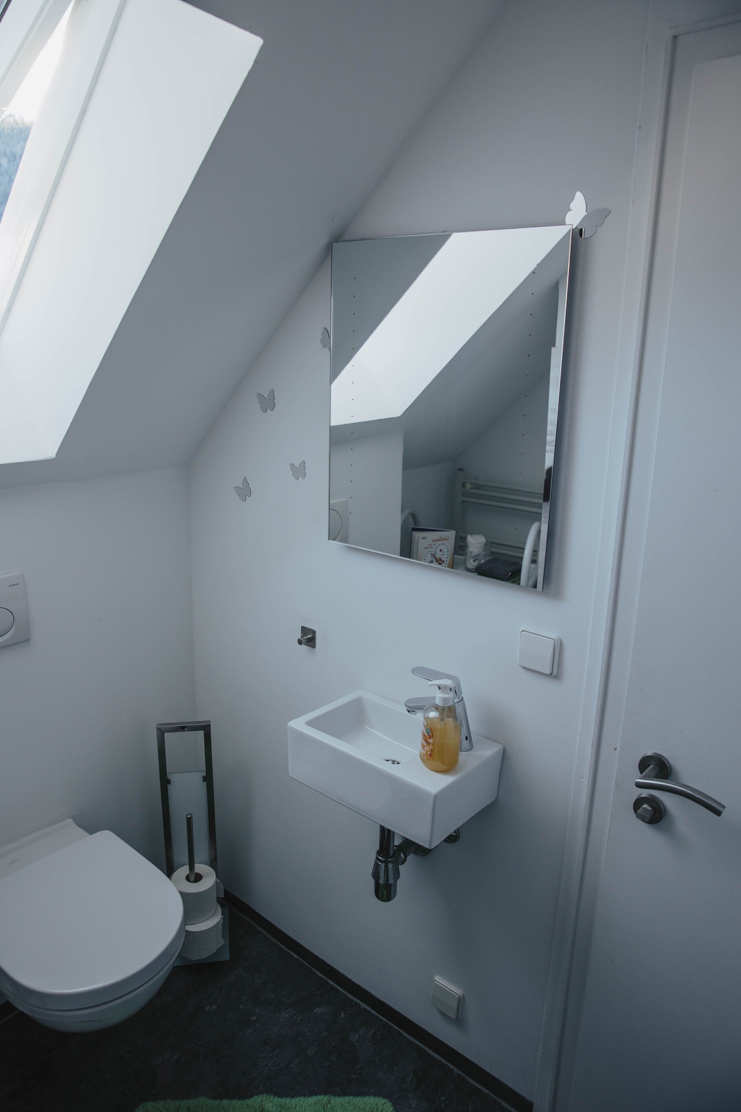 Un baño con inodoro, lavamanos y espejo.