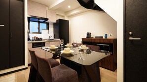 A modern kitchen with a dining area, equipped with a refrigerator, oven, and microwave. - Penthouse 1-bedroom Flat in Hiroo Shibuya (Tokyo)