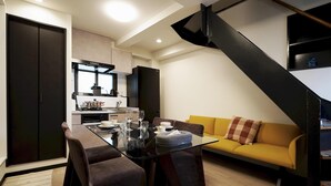 A modern living space with a dining area, sofa, and kitchen. - Penthouse 1-bedroom Flat in Hiroo Shibuya (Tokyo)