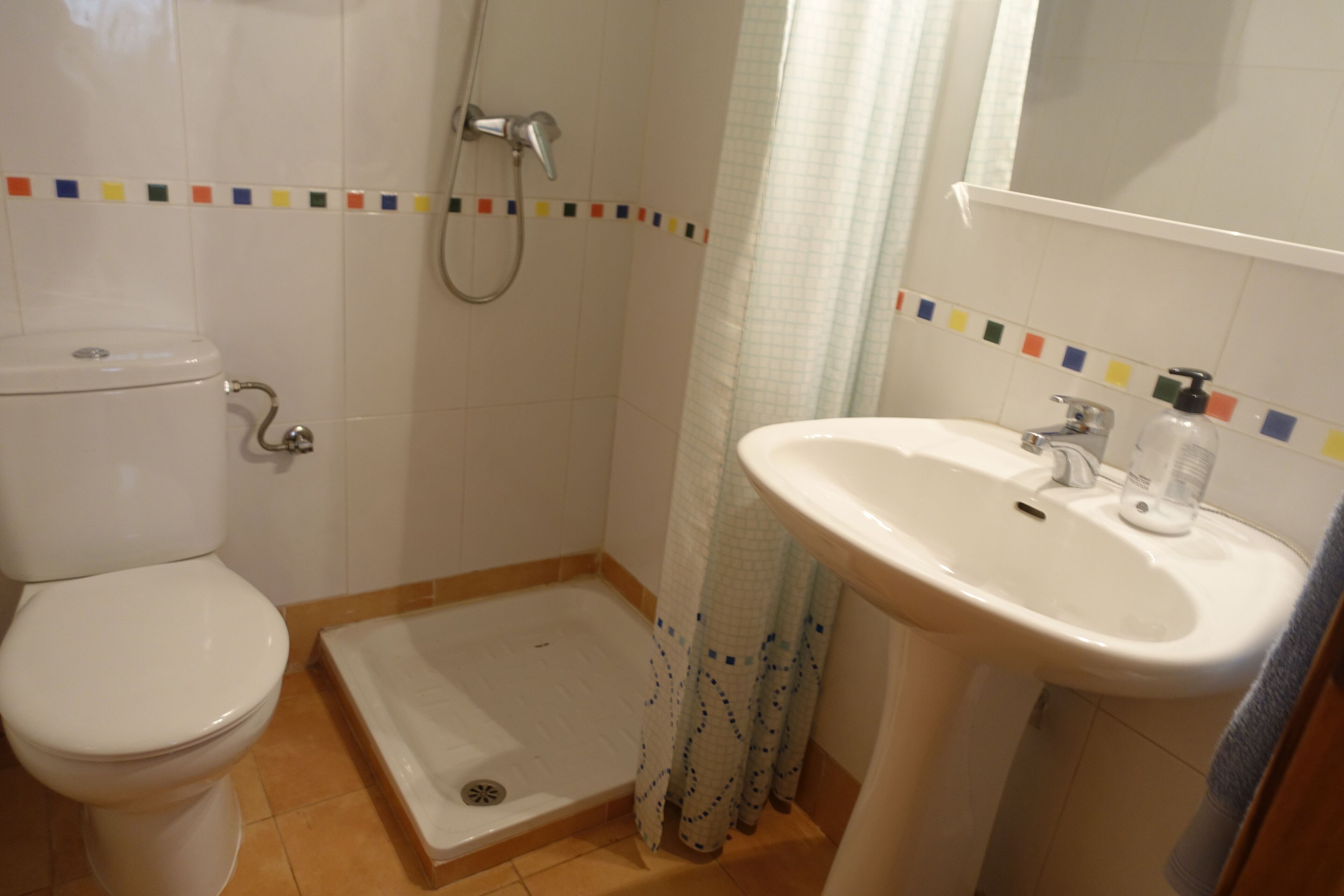 Un baño con inodoro, ducha y lavamanos.