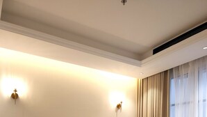 Un dormitorio moderno con una cama grande, dos mesitas de noche e iluminación empotrada.