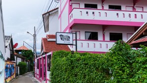 A pink and white building with a sign for 'Slumber Party Hostel & Bar'. - Slumber Party Chiang Mai (Chiang Mai)