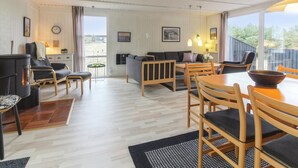 A cozy living room with a fireplace, sofa, dining table, and chairs. - "Florencia" - 450m from the sea by Interhome (Løkken)