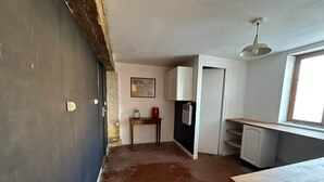 Una cocina con refrigerador, pileta y ventana.