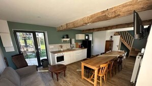 Eine moderne Küche mit weißen Schränken, einem Holztisch und einem eingebauten Backofen.