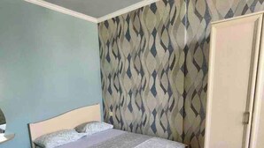 A bedroom with a bed, wardrobe, and patterned wallpaper. - Best Location, Cozy Spacious Apart Near Republic (Yerevan)