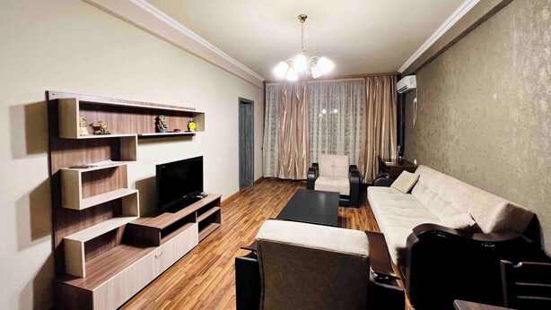 A modern living room with a sofa, TV, wooden entertainment unit, and a dining area. - Best Location, Cozy Spacious Apart Near Republic (Yerevan)