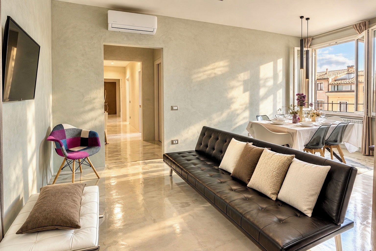 A modern living room with a leather sofa, a colorful chair, and a dining area with a table and chairs.