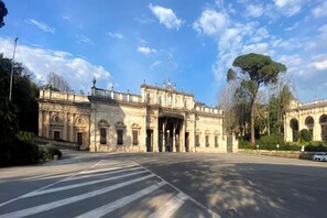 A historic building with classical architecture, a wide entrance, and a flagpole.