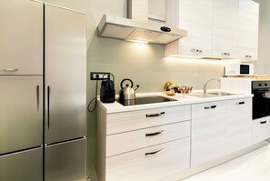 A modern kitchen with white cabinetry, a stainless steel refrigerator, a kettle, and a microwave. - Signature Design & Panoramic Views in the heart of Montecatini Terme (Montecatini Terme)