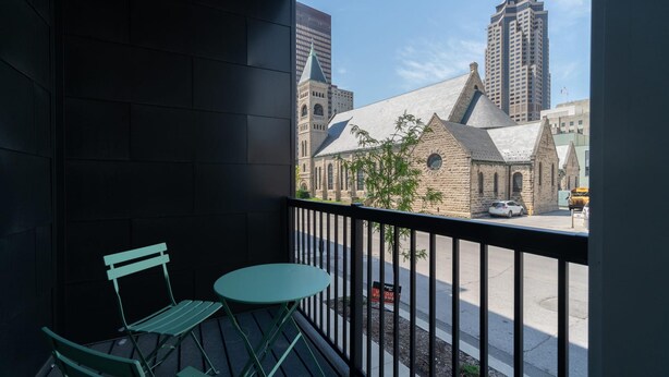 A balcony with a view of a historic church and modern buildings. - Des Moines Designer 1BD 1BA Downtown Apartment (Des Moines)