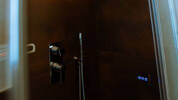 A modern shower with a control panel and a glass door.