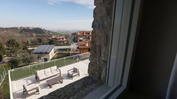 Ein Balkon mit Blick auf eine Wohngegend, darunter Häuser und Solaranlagen.