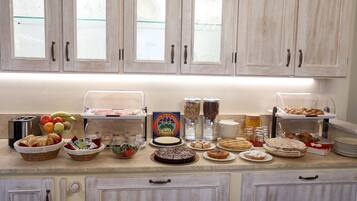 Un ricco buffet per la colazione con diversi cibi e un angolo caffè.