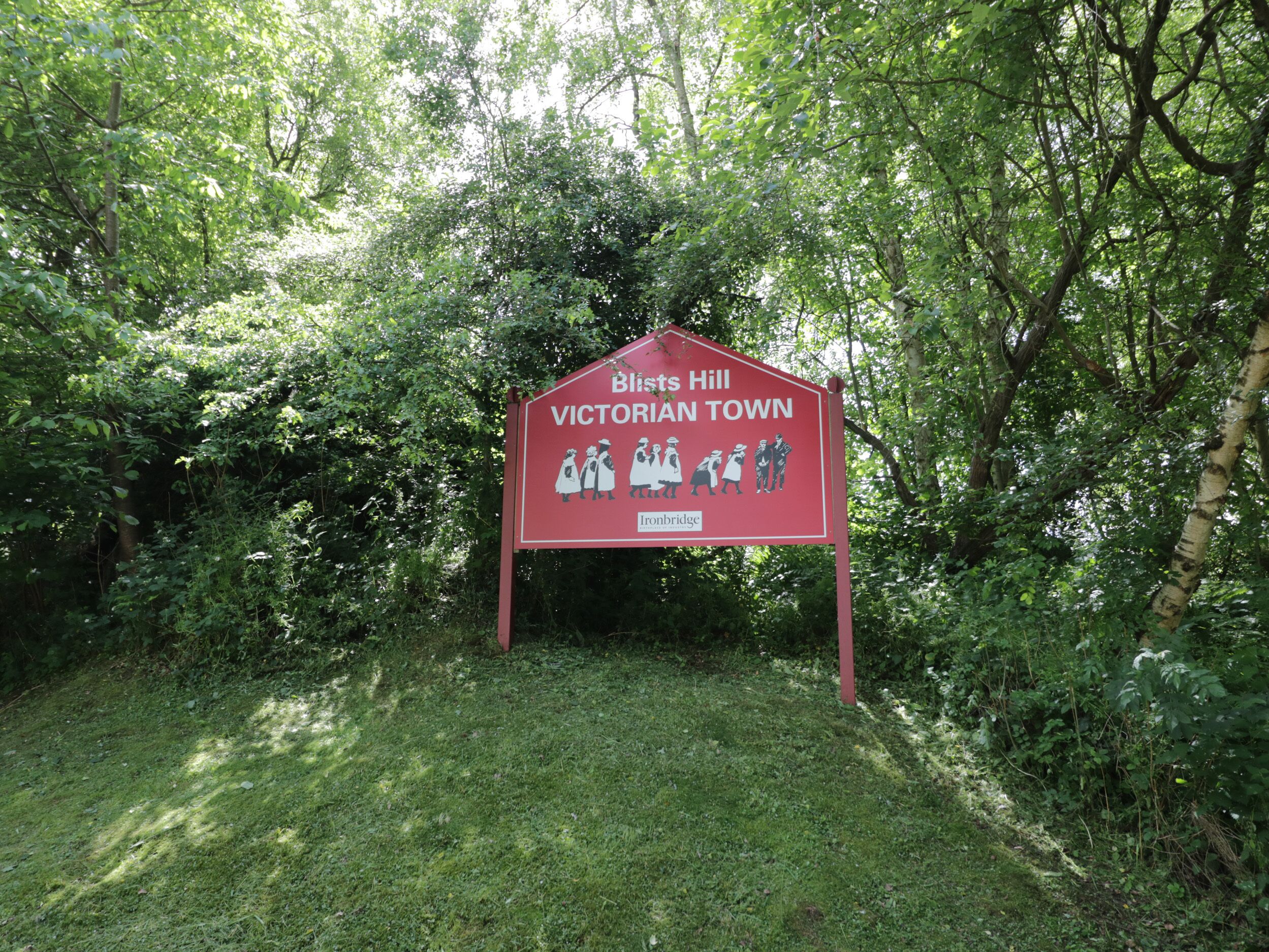 A red sign with white lettering indicating 'Birst Hill Victorian Town' and 'Ironbridge.'