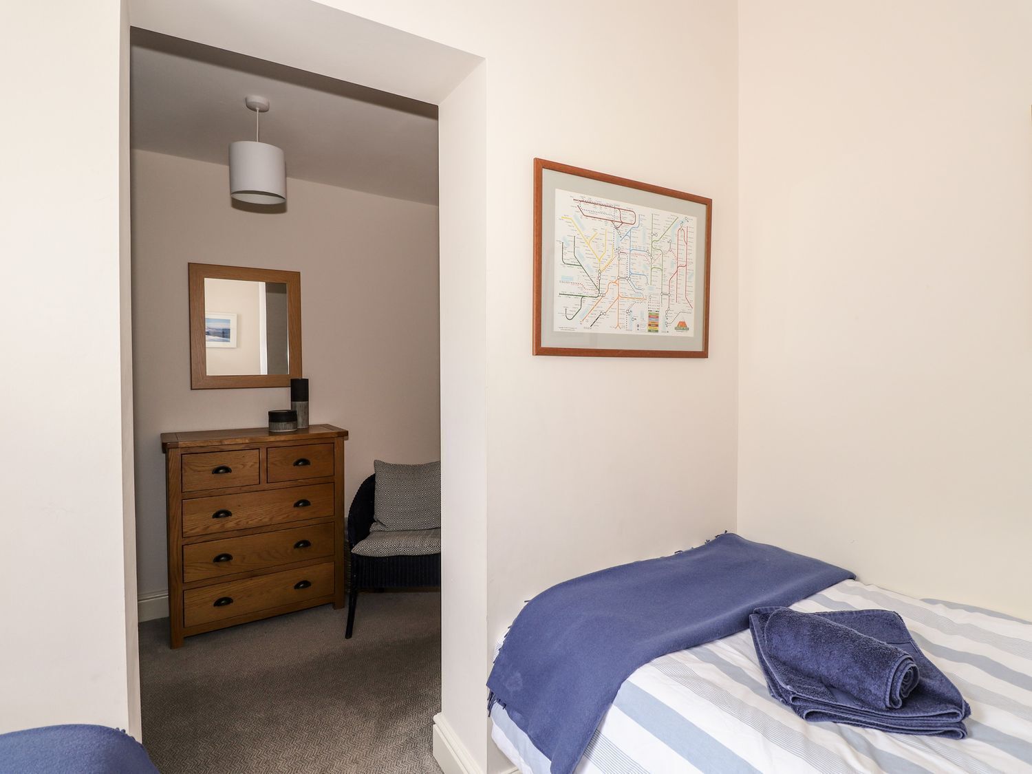 Ein Schlafzimmer mit einem Bett, einem Schminktisch, einem Spiegel und einer Karte an der Wand.