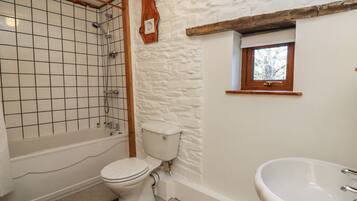 A bathroom with a bathtub, toilet, and sink.