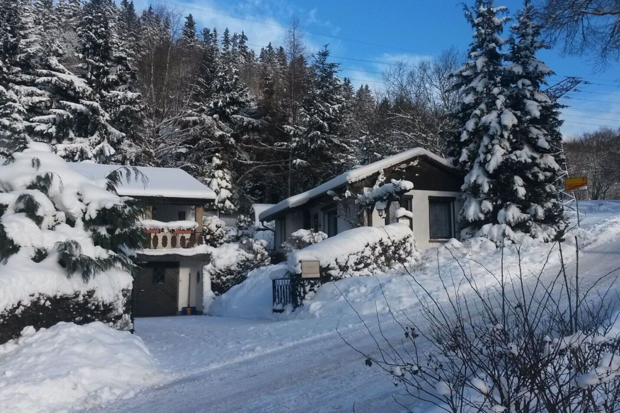 Ein mit Schnee bedecktes Wohngebiet mit Häusern und blauem Himmel.