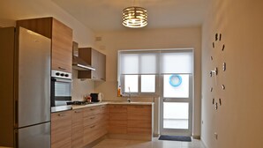 Eine moderne Küche mit Holzausstattung, einem Einbauofen und einem Edelstahl-Kühlschrank.