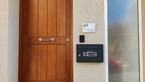 Eine Holztür mit Briefkasten und Hausnummer.