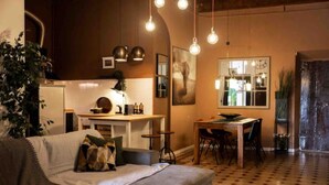A cozy living room with a sofa, a dining table, and hanging light fixtures. - Renaissance Residence In San Miniato with a view (San Miniato)