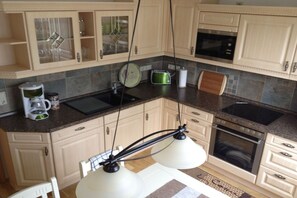 A kitchen with a double sink, a microwave, a toaster, and a coffee maker.