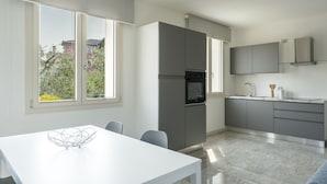 A modern kitchen with a large window, a refrigerator, and a sink.