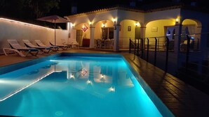 Une piscine dotée de chaises longues et d’un espace de repos abrité.