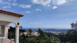 Un bâtiment blanc doté d’un balcon donnant sur un paysage pittoresque.