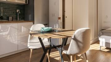 Una cocina moderna con una mesa de comedor, sillas y un microondas.