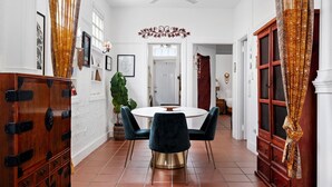 A dining area with a round table, dark chairs, and a decorative ceiling fan.