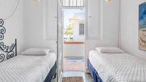 A bedroom with two beds, a window, and a view of the outside. - Multi-unit beachside complex for up to 12 guests! (Santurce)