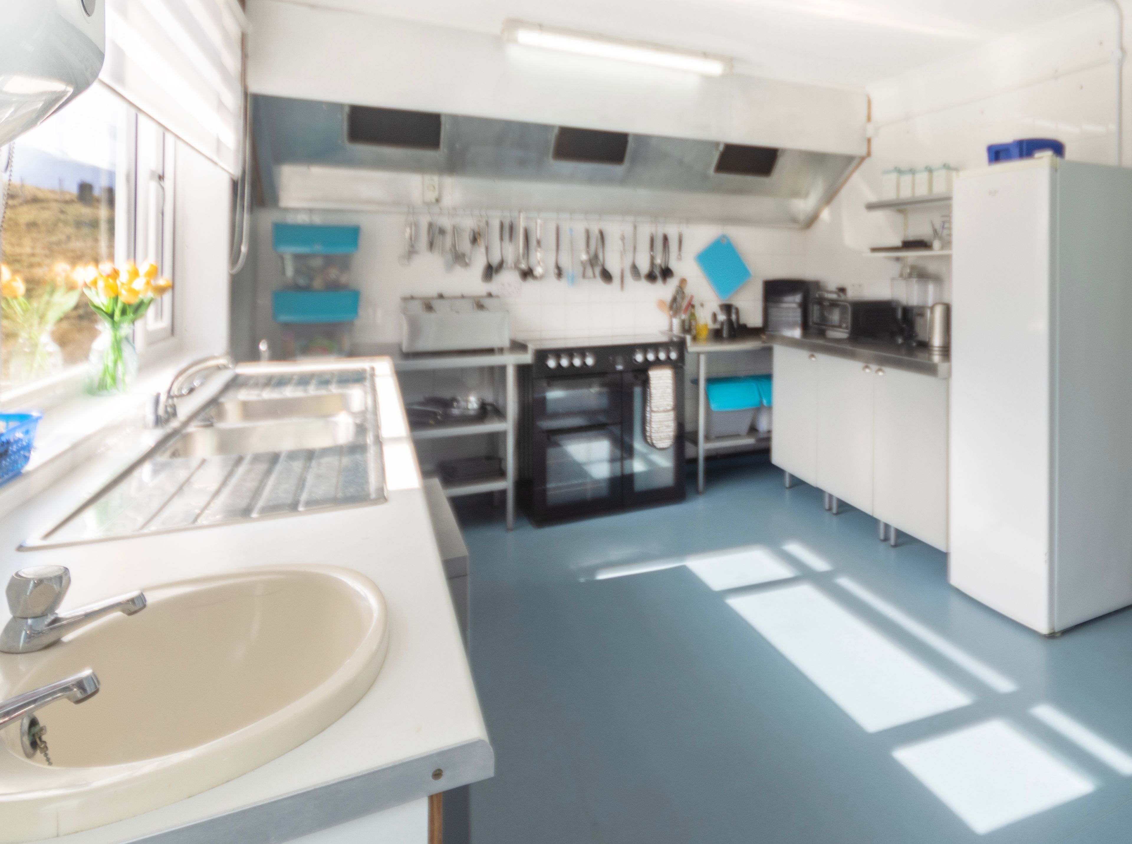 A modern kitchen with a sink, stove, oven, and cabinets.