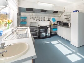 Una cocina moderna con pileta, estufa, horno y alacenas.