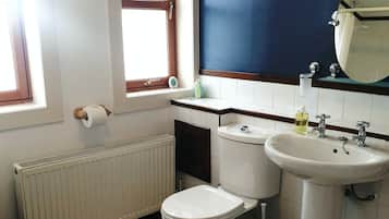 Ein Badezimmer mit Toilette, Waschbecken und Fenster.