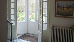 A room with a large bay window, a radiator, and a painting on the wall.