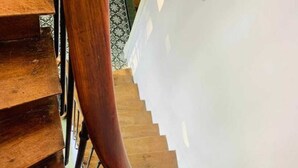 A wooden spiral staircase with a metal handrail.
