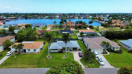 A residential area with houses, a marina, and a large body of water.. Coastal Charm with Heated Pool
