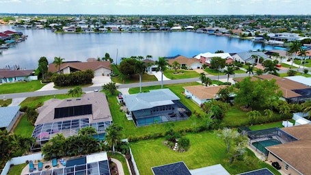 A residential area with houses, a large body of water, and a clear sky.. Coastal Charm with Heated Pool