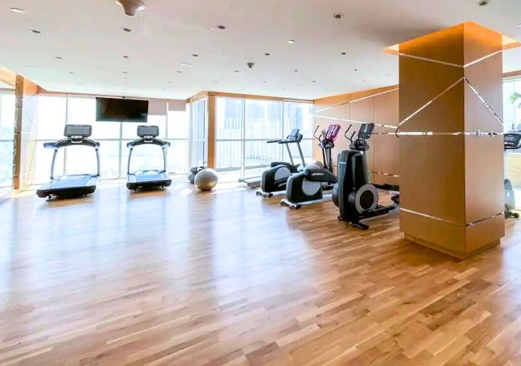 A spacious gym with treadmills, elliptical machines, and a large exercise ball.
